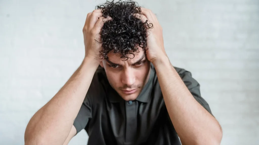 Hombre preocupado tocandose el cabello sufriendo apego ansioso Psicologa Rosa Torrejon en San Fernando